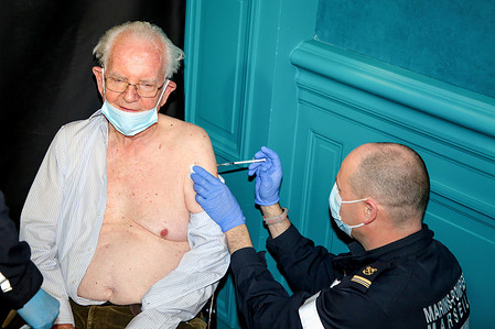 A man receives his first injection of Pfizer vaccine at a COVID-19 vaccination center in Marseille.