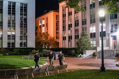 Police officers walk at Krentzman Quad at Northeastern University. Northeastern University lifts "shelter in place" order after Boston police responded to a bomb threat report on campus.
