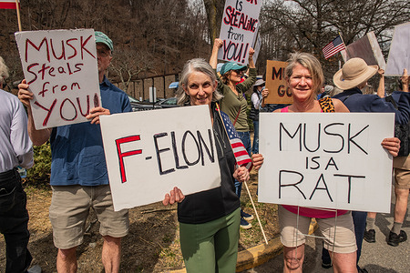 Protesters hold placards during the demonstration. During the mass nationwide Hand's-Off protest, thousands of people gathered to march against the recent changes made by the Trump administration that are now affecting Americans across the country.