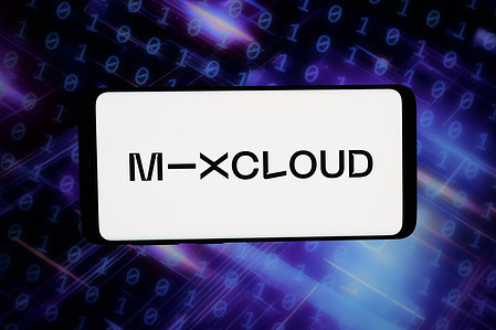 In this photo illustration, the logo of British music streaming service Mixcloud is displayed on a smartphone in front of abstract background on computer screen.