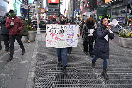 A protester holds a placard raising awareness of the death of Dominique Alexander during a rally in Times Square.
The New York Police department determined that the cause of death of Dominique Alexander found hanging from a tree in Fort Tyron Park on June 9, 2020, was suicide. This incident predates other hangings of black men in California under suspicious circumstances, prompting further investigation by the US Attorney.