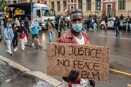 A protester holds a placard that says No Justice No Peace during the demonstration.Under a heavy rain, people gathered in Milano in solidarity with the Black Lives Matter march following the killing of George Floyd, a black man who died in police custody in Minneapolis. The event was organized by: Abba Vive, Black Diaspora Art, Festival DiversCity, Todo Cambia, Razzismo Brutta Storia, Afro Fashion Week Milano and had seen the participation of many civil associations.