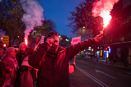 Protesters carry smoke flares during a demonstration. Protesters stage a demonstration organized by various social groups in the Carabanchel neighborhood of Madrid to protest the existence of Foreigners' Detention Centers (CIEs) in the city, which they consider illegal.