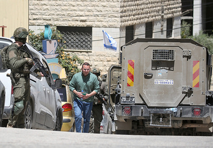 Israeli soldiers escort a Palestinian man from the café during an army raid in the Rafidia neighborhood of Nablus in the West Bank. The army stormed the café and arrested dozens of Palestinians. A Palestinian man in his twenties was killed during the operation.