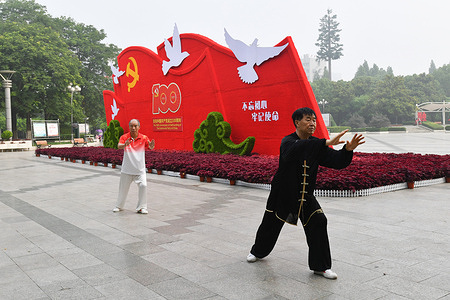 At Qinghe square in Fuyang City, two men practice Tai Chi in front of a sign "Celebrating the 100th anniversary of the founding of the Communist Party of China".
July 1, 2021 is the 100th anniversary of the founding of the Communist Party of China. As the date approaches, relevant commemorative signs are everywhere in China, and the flag of the Communist Party of China is hung, so as to create a red atmosphere to celebrate the 100th anniversary.