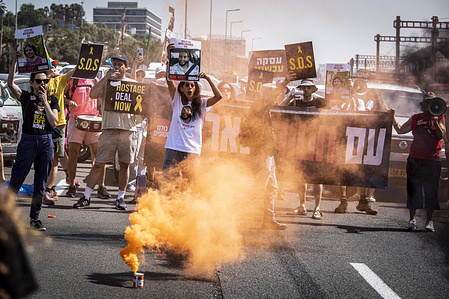 Einav Zangauker Mother of Matan who is held hostage in Gaza stands with supporters next to a smoke candle blocking the Ayalon highway in Tel Aviv. Anti-government protest organizations launched a day of demonstrations on Thursday all over the country blocking major highways and calling for Israel to press ahead with a deal to release hostages held by Hamas in Gaza, to end the war and for the ouster of Prime Minister Benjamin Netanyahu and early elections.