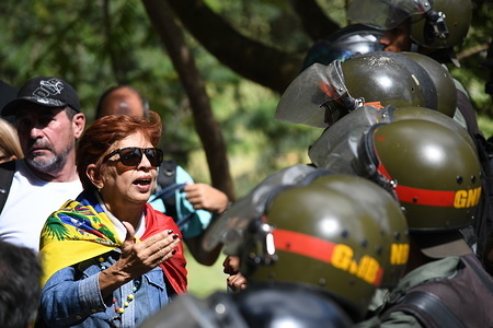 A family member of one of the victims seen covering herself with the Venezuelan flag to confront the police during the funeral.
Government of Nicolas Maduro, buried José Diaz Pimentel and Abraham Agostini without the consent of his family. Pimentel and Agostini were part of the rebel group of the police officer together with Oscar Perez turned against the Maduro government. 4 bodies were moved to another state of the country and the body of Oscar Perez will be buried in Caracas.