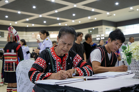 A Thai hill tribe member signs a condolence book and pays their respects to the late Queen Mother Sirikit at the Chiang Mai International Exhibition and Convention Centre in Chiang Mai. Queen Mother Sirikit passed away at the age of 93 on October 24, 2025, at King Chulalongkorn Memorial Hospital in Bangkok, according to the Royal Household Bureau.
