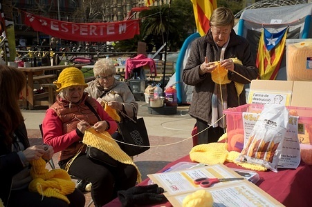 Barcelona, Catalunya Square. "Grandmother's weapon of massive destruction", is the sentence that these old women had over the table while they are weaving. Jubilee people are protesting around Spain to defending their pensions. Spanish financial crisis put at risk the retirement benefits. Workers unions have organized national protests on 22 February 2018.