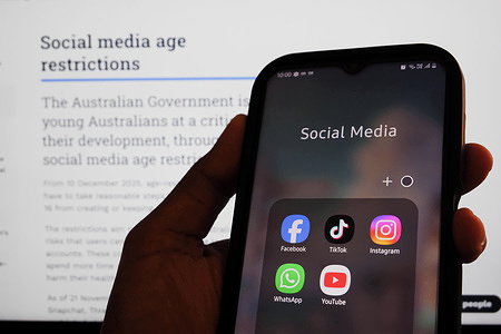 In this photo illustration, the social media networking apps are displayed on a phone with the eSafety Commissioner website displayed in the background. The Online Safety Amendment (Social Media Minimum Age) Act 2024 requires social media platforms, including TikTok, Instagram, Facebook, YouTube, Snapchat, X, Reddit, Threads, Twitch, and Kick to implement age-verification systems and take reasonable steps to prevent account creation by users under 16, with non-compliant platforms facing penalties of up to A$50 million.