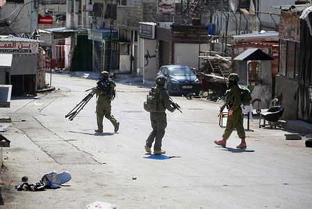 Israeli soldiers take positions in the middle of the market in the Askar refugee camp during a military operation. Israeli army forces raided the Askar refugee camp east of Nablus in the West Bank, conducting a large-scale military operation, searching homes and shops for weapons and arresting dozens of young Palestinians.