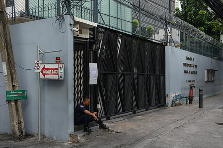 A security guard of the Myanmar Embassy is seen seated and smoking in front of the embassy. Myanmar conducted advance voting at its embassy in Thailand under tight Thai police security, with a quiet atmosphere and only a small turnout of Myanmar voters