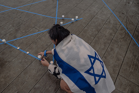 Close-up of candles, their flames casting a warm and peaceful glow in the twilight. Over a hundred protesters gathered at Pier 62 in Seattle to light candles and offer prayers for those affected by the ongoing conflict in Israel. The rallies, marked by a sense of unity and empathy, lasted for an hour, sending a message of hope and solidarity.
