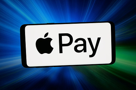 In this photo illustration, the mobile payment service Apple Pay logo is seen displayed on a smartphone in front of abstract background on computer screen.