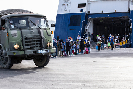 Refugees boarding a ferry at the Mytilene Port for a transfer on the mainland.
The new camp Kara Tepe, also known as Moria 2.0, is a temporary tent construction that the Greek government has built after the fire in Moria 9th September. The camp is hosting 7500 asylum seekers and was built on the edge of the sea on a former military shooting range.
After the fire in Moria on 9th September, 2020 the greek government built in 10 days a new camp on the edge of the sea on a former military shooting ground called "new Kara Tepe", also know as "Moria 2.0".
In the week following the fire, the Greek government sent units of riot police to contain the fleeing asylum-seekers on the road between Moria and the main town of Mytilene, later forcing them to enter in the new camp Kara Tepe.
When police operation was finished almost 10.000 people were living inside the new camp.
Later the government decided to reduce the population inside the new Kara Tepe camp and started some transfers operation reducing the population number at almost 7.500 people.
All the refugees with already the accepted asylum papers for the mainland of Greece were move to the Mainland, from Lesbos to Athens (some of them also transferred in Thessaloniki and Kavala).