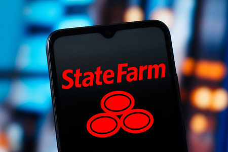 In this photo illustration, the State Farm Insurance logo is seen displayed on a smartphone screen.