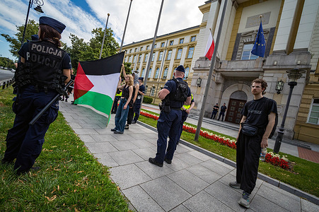 Activists display the Palestinian flag outside the entrance of the Chancellery of the Prime Minister of Poland during the demonstration. On the afternoon of the 5th of August, the eve of the swearing in of Poland's new president, pro-Palestinian activists blocked the road outside the Chancellery of the Prime Minister of Poland in Warsaw. The protesters were calling for the end of the government's cooperation with the government of Israel. Protesters blocked the road with a banner and lit flares before police pushed them to the side of the road, where the protest continued.