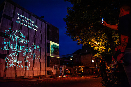A man seen taking photos of the projection. The 80th Battle of Arnhem is commemorated, at dusk, special projections illuminate buildings in the city center. The Battle of Arnhem was fought during Operation Market Garden. Operation Market Garden was designed to catch the German forces by surprise, capturing Arnhem and its important bridges over the Rhine before they could be destroyed by the defenders. It was the largest airborne assault in history and one of the most ambitious Allied operations of the Second World War.