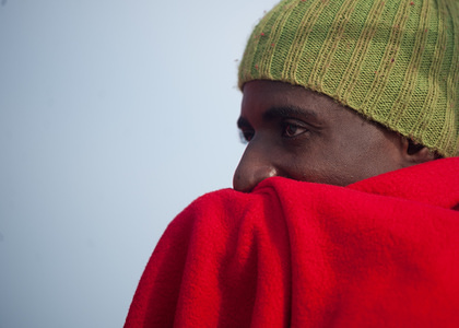 A migrant looks on from a Spanish coast guard vessel. A group of 80 migrants were rescued from a dinghy in the Mediterranean. The migrants arrived at the Port of Málaga. Among them were 6 women and 4 children.