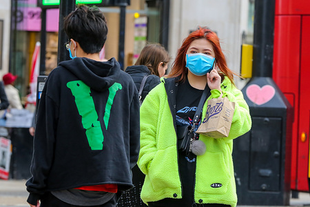 A woman wearing a face mask as a preventive measure against the corona virus speaking on her mobile phone in central London.
8 people have died from the virus and the number of coronavirus cases in the UK has increase to 456.