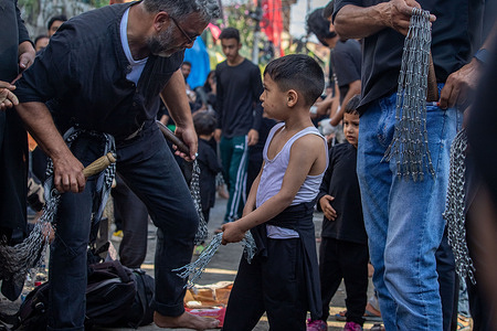 Shiite Muslim boy holding chains as he prepares to flagellate himself during a religious procession on the tenth day of Ashura in the Islamic month of Muharram, in Srinagar. Ashura or (10th day of Muharram) marks the martyrdom of Imam Hussain, the grandson of Prophet Mohammed and his immediate family members who were killed in the Battle of Karbala in Iraq in the 7th century.