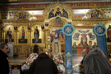 People listen to a sermon from a priest in the lower part of the Transfiguration Cathedral. Orthodox Christians celebrate Christmas according to the Julian calendar in the Transfiguration Cathedral, despite the significant damage it sustained from a Russian missile strike.