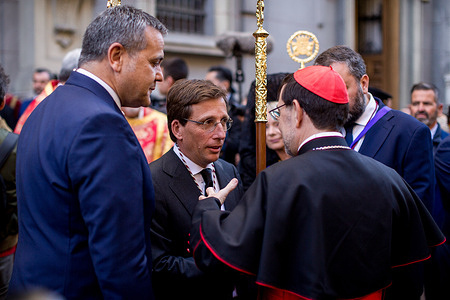 Jose Luis Martinez-Almeida, Mayor of Madrid, speaks with Cardinal Jose Cobo in the center during the procession with the image of Jesus of Medinaceli through the streets of Madrid on Good Friday.