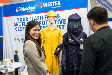 An exhibitor is seen smiling while showing products to a customer at the Industrial Safety Equipment booth for Petrochem, during the Thailand Marine & Offshore Expo (TMOX) 2025, Oil & Gas Thailand (OGET) 2025, and Powerex & Electric Asia 2025 at BITEC. Three major global industrial exhibitions join together: Thailand Marine & Offshore Expo (TMOX) 2025, Oil & Gas Thailand (OGET) 2025, and Powerex & Electric Asia 2025, at BITEC (Bangkok International Trade & Exhibition Centre) in Bangkok. Together, these three exhibitions showcase the latest innovations across the marine and offshore sector, energy and electrical technology, and the oil, gas, and petrochemical industries.