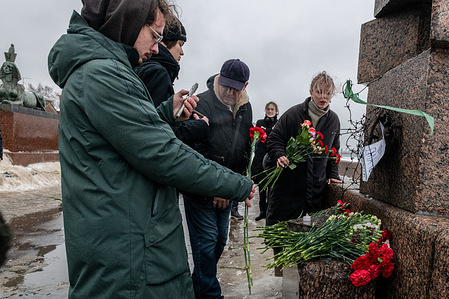 People gather at a monument to victims of political repression to honor the memory of Russian opposition leader Alexei Navalny a day after news of his death, in St. Petersburg.