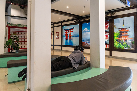 A visitor seen in the seating area in front of murals depicting iconic Japanese landmarks at J-Park Sri Racha Nihon Mura Mall. J-Park Sri Racha Nihon Mura, a Japanese-themed community mall in Chonburi province was created to serve the large Japanese community established around Thailand's Eastern Seaboard industrial corridor. Designed in the style of a traditional Japanese town, the complex reflects the long-standing ties between Japanese industry and the Sriracha region.
