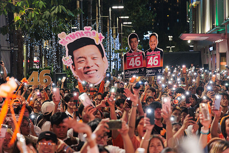 Supporters hold a poster of Natthaphong Ruengpanyawut during a public speaking event held by People's Party at Samyan Mitrtown.
