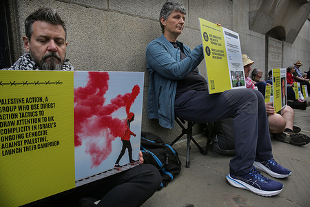 Supporters of Defend Our Juries hold placards during the protest outside court. Supporters of the Filton 18 gather outside the Old Bailey in solidarity with the Palestine Action prisoners being accused under counter terrorism powers of destroying Israeli weaponry being made at Elbit Systems’s Filton facility in Bristol. Several activists marched into the factory in an adapted prison van in August 2024 and damaged property, including quadcopter drones worth over £1 million. Police arrested the suspects under the Terrorism Act, allowing them to hold and question the suspects for an extended time, and they have all been remanded to prison ever since. The event occurred as it was revealed this week after a freedom of information request that counter terrorism police and the Crown Prosecution Service (CPS) are communicating with the Israeli embassy, giving them access to interfere in Palestine Actionists’ prosecutions.