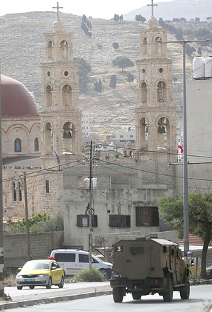 Israeli military vehicles pass in front of an Orthodox church during a military operation. Israeli forces raided a house in Balata al-Balad, east of Nablus, in the West Bank. During the operation, Israeli forces arrested a Palestinian wanted by the occupation forces in the Palestinian Authority territories in the town of Balata al-Balad.