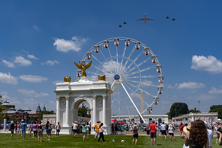 Aircraft fly past the ferris wheel and a mockup of President Donald Trump's proposed Triumphal Arch at the Great American State Fair on the National Mall as part of "Wings of Freedom" day in Washington.