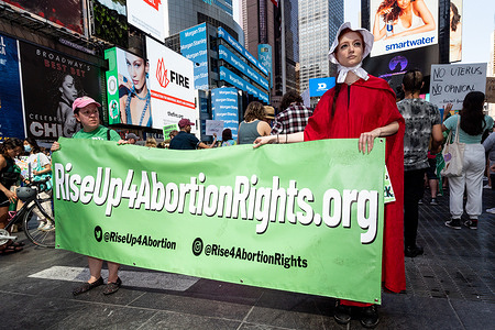 Women hold a banner saying "RiseUp4AbortionRightts.org" at an abortion rights demonstration in New York City.