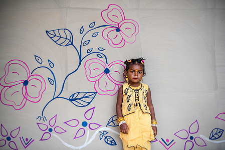 A child poses for a photo in front of her painted house in Rajshahi.
Santal tribe is an ethnic group native to eastern India. Santals are the largest tribe in the Jharkhand state of India in terms of population and are also found in the states of Assam, Tripura, Bihar, Odisha and West Bengal. They are the largest ethnic minority in northern Bangladesh's Rajshahi Division and Rangpur Division.