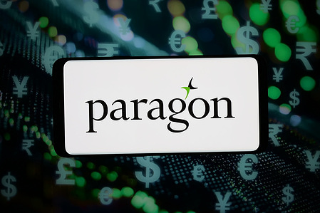 In this photo illustration, the logo of British company Paragon Banking Group plc is displayed on a smartphone in front of abstract background on computer screen.
