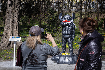 People take a pictures of a monument depicting the cartoon character Stitch from the cartoon 'Lilo and Stitch' in military uniform, erected in honor of the Ukrainian sniper Ihor Voevodin with nickname Stitch, who died in battles with the Russian army, in central Kyiv. Ukrainian student Ihor Voevodin volunteered for the front after the Russian invasion and served as a sniper in Azov regiment. Ihor Voevodin was killed in August 2023 on a combat mission in Luhansk region, Ukraine.