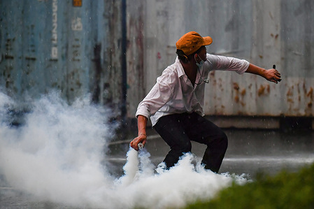 A protester throws a tear gas grenade back at the riot policemen during the demonstration.
Pro-Democracy protesters rallies at various establishments' calling for the Thai Prime Minister, Prayut Chan-o-cha to resign, reform the monarchy and better policies for the COVID-19 situation. The demonstration ended in a clashes with police forces.