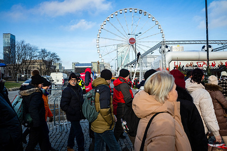 The first visitors to the Christmas Market make their way inside upon opening. On the weekend of the 28th of November through to the 30th of November, the city of Warsaw opens its new Christmas Market (Jarmark Warszawski) at Plac Defilad. The market is open until the 1st of January 2026. Visitors can enjoy over 150 wooden cottage stalls, an open-air cinema, Poland's largest Big Wheel, rides, attractions, and light sculptures, not to mention an array of foods and mulled wine.
