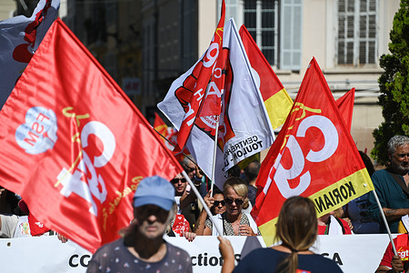 Protesters seen holding flags as they march through the streets during the demonstration. Members of an inter-union trade coalition staged a street demonstration in Marseille to protest ongoing economic policies and austerity measures. The mobilization brought together workers and union representatives, calling on the government and employers to implement salary hikes and safeguard purchasing power.