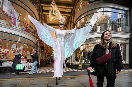 An elegant stilt-walker poses for photos with shoppers in the centre of a car-free Regent Street. Regent Street was closed to traffic for the first time since 2020 to free the road for Christmas shoppers and festive celebrations. The road was shut between Oxford Circus and Piccadilly Circus to transform it into a festive mile of shopping, entertainment, and refreshments organised by the Crown Estate.