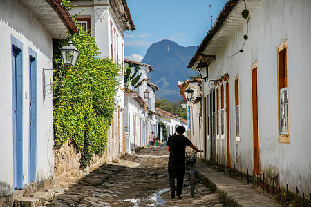 A passerby pushes his bike down a street in the historic center of Paraty.