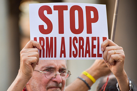 An activist holds a placard during a flash mob protest against Italian political and military cooperation with Israel, in Piazza della Rotonda, near the Pantheon.