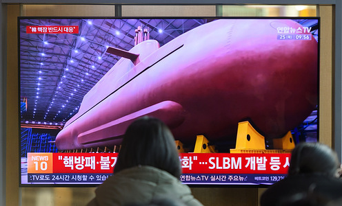 People seen looking at a 24-hour Yonhap news TV broadcast at Seoul Railway Station showing news broadcast that shows North Korean leader Kim Jong Un veiling manufacturing site of an 8,700-tonnage nuclear-powered strategic guided missile submarine at an undisclosed location. North Korean leader Kim Jong Un has said South Korea's plan to build nuclear-powered submarines will "worsen the instability" in the region, calling South Korea's move a threat to the North's national security, according to state media on December 25.
North Korean leader Kim Jong Un made the remarks during an on-site inspection of an 8,700-ton nuclear-powered strategic guided missile submarine under construction, the Korean Central News Agency (KCNA) said.