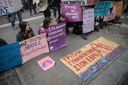 Protesters are seen seated on the street while holding placards during the protest.
Women demonstrate about the eradication of violence against women.