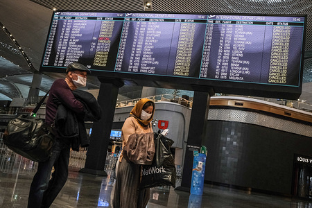 People wearing protective masks stand next to an electronic board showing cancelled flights due to he COVID-19 pandemic at the Istanbul Ataturk Airport.
Turkey has announced new strict measures to curb the spread of coronavirus in the country. The government has imposed a travel ban on thirty cities and banned all international flights.