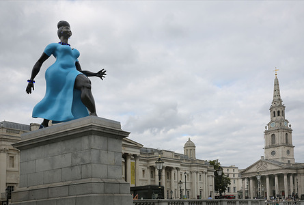 The Lady in Blue with her modern shape and movement is viewed against the classic statue of Nelson's Column in Trafalgar Square. The Lady in Blue is the latest sculpture to be installed on the Fourth Plinth. Lady In Blue, a bronze and blue sculpture by New York artist Tschabalala Self is the 16th artwork to grace Trafalgar Square’s skyline. The artist was inspired by the idea of a contemporary "everywoman." The sculpture depicts a young metropolitan woman walking forward with ambition and purpose and sits juxtaposed to the classical sculptures and buildings like Nelson’s Column and the National Gallery that have become fixtures of the famous square for centuries.
