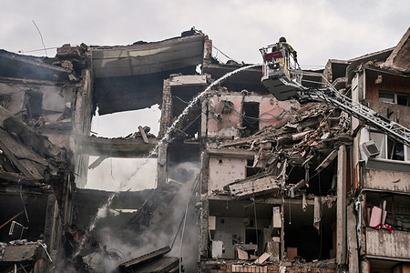 Firefighters extinguish a fire in an apartment building partially destroyed by a Russian strike. Russia struck Ukraine's Kyiv region with ballistic missiles on July 6, killing at least eight people and wounding dozens, authorities said, on the eve of a NATO summit in Turkey.