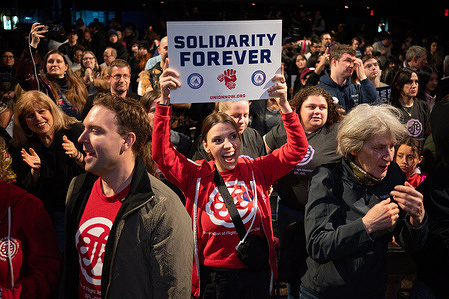 An attendee raises her sign up during the ''Union Now'' rally at Temrinal.